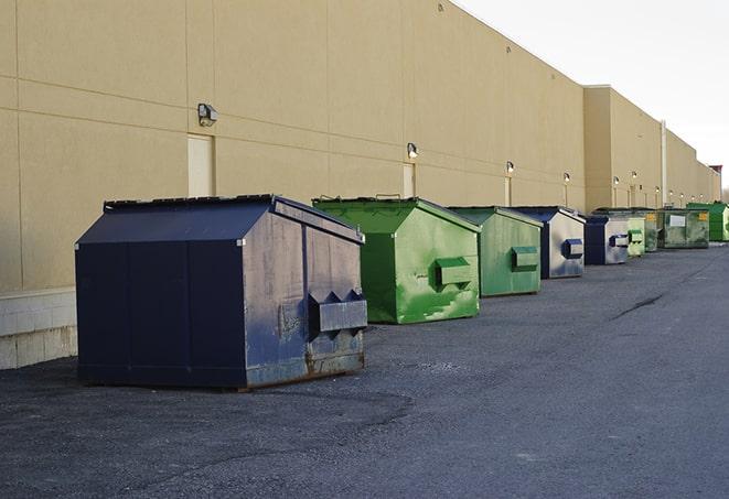 a crowd of dumpsters of all colors and sizes at a construction site in Falcon